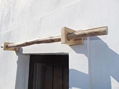 a close up of a wooden object on the side of a building with a door