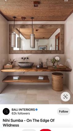 a bathroom sink sitting under a mirror next to a wooden shelf with two vases on it