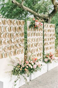 a wall decorated with flowers and jute hats for an outdoor wedding or reception area