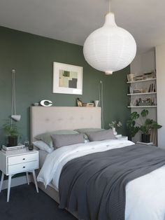 a bedroom with green walls and white furniture