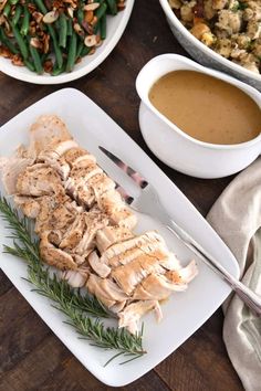 a white plate topped with chicken next to green beans and rice covered in gravy