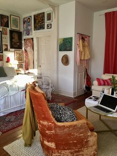 a living room filled with lots of furniture and pictures on the wall next to a bed