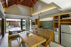 an open kitchen and dining area with wooden furniture in the center, along with sliding glass doors leading outside