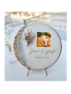 a white table topped with a plate covered in pictures and flowers on top of it