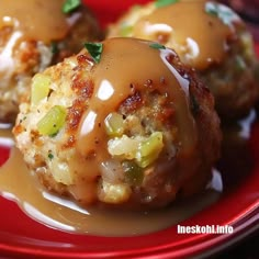 some meatballs covered in gravy on a red plate