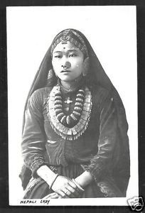 an old black and white photo of a woman wearing a headdress with necklaces