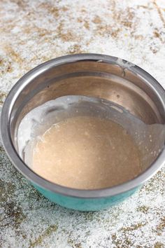 a metal bowl filled with batter on top of a table