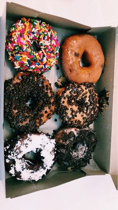 a box filled with lots of different flavored donuts