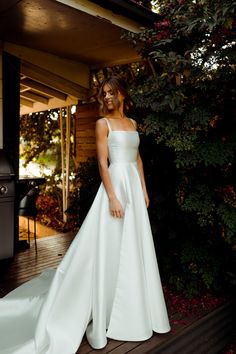 a woman in a white dress standing on steps