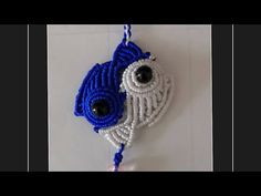 a blue and white beaded bird ornament hanging on a wall