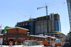 some construction cranes and buildings in the background