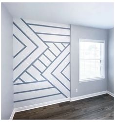 an empty room with wood flooring and painted wall designs on the walls in it