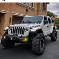 a white jeep is parked in front of a house with its lights on and the door open