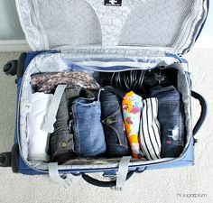 an open suitcase filled with clothes on the floor