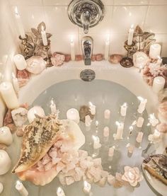 a bathtub filled with candles and sea shells