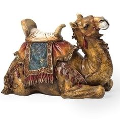 a ceramic figurine of a camel sitting on the ground with its back turned