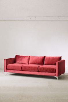 a red couch sitting on top of a white floor