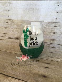 a green wine glass with the words don't be a prick printed on it