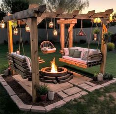 an outdoor fire pit with swings and chairs