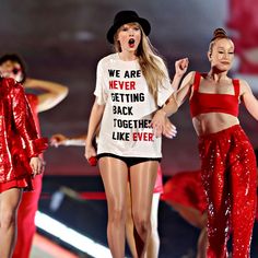 three women in red outfits on stage with one wearing a t - shirt that says we are never getting back together