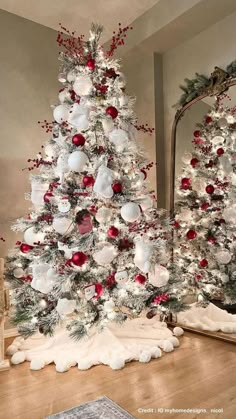 a white christmas tree with red and silver ornaments