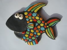 a ceramic fish with multicolored dots on it's body