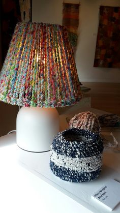 two knitted lamps sitting on top of a table next to a lamphade