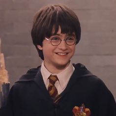 a young boy wearing glasses and a harry potter sweater