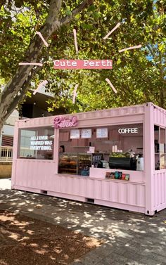 a pink coffee shop sitting under a tree