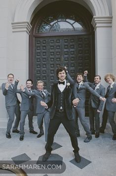 a man in a tuxedo is dancing with his hands up to the side