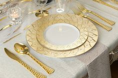 the table is set with gold and white plates