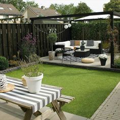 an outdoor living area with green grass and white furniture