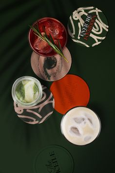 three different types of drinks sitting on top of a green table with the same label