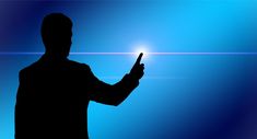 a man holding a cell phone in his right hand and pointing to the light at him