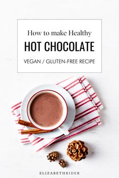 a cup of hot chocolate on top of a red and white towel next to some nuts