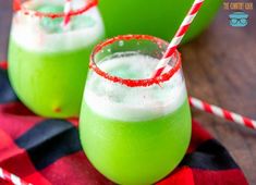 two glasses filled with green liquid and topped with candy canes