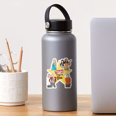 a silver water bottle sitting next to a white laptop and pencils on a table