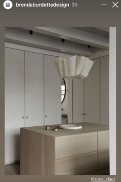 an image of a kitchen with cabinets and lights on the ceiling, in front of a mirror