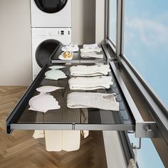 clothes are drying on a rack in front of a washer and dryer machine