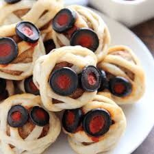 small pastries on a white plate with red and black toppings, ready to be eaten