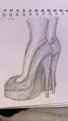 a drawing of a pair of high heeled shoes on top of a table next to a notebook