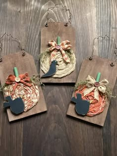 three pieces of wood are decorated with fabric and bows, some have tags attached to them