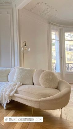 a white couch sitting on top of a hard wood floor