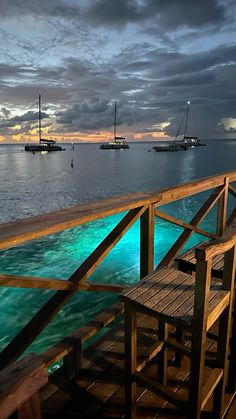 a dock that has some boats in the water on it and is lit up with blue lights