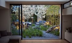 a living room filled with lots of furniture and flowers on the window sill next to it