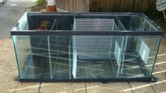 a large fish tank sitting on top of a wooden floor next to a fenced in area