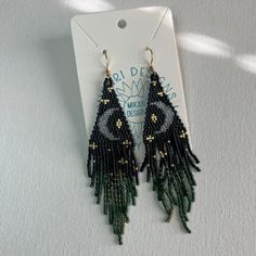 the earrings are made with seed beads and beaded in black, green and gold