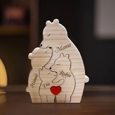 a wooden bear holding a heart on top of a table