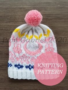 a knitted hat with a pink pom - pom on the front and yellow,