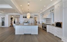 a large kitchen with white cabinets and an island